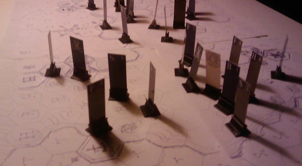 Close-up of a part of the sketched game board with a lot of tokens on them. The board consists of hexagon shaped fields, with arced coast lines.